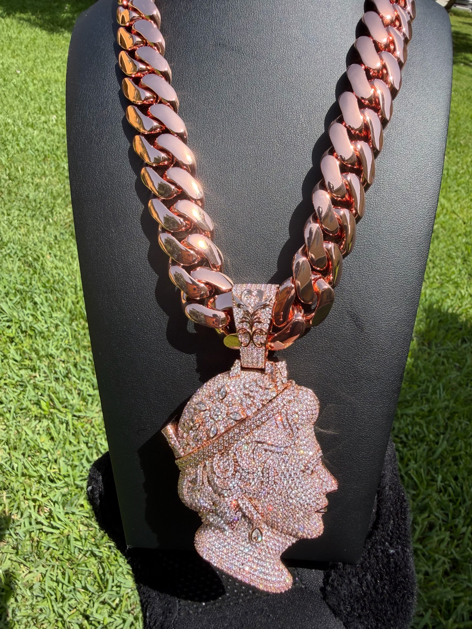 Virtue Jewel rose gold cuban link chain with an iced-out queen portrait pendant on a black display bust.